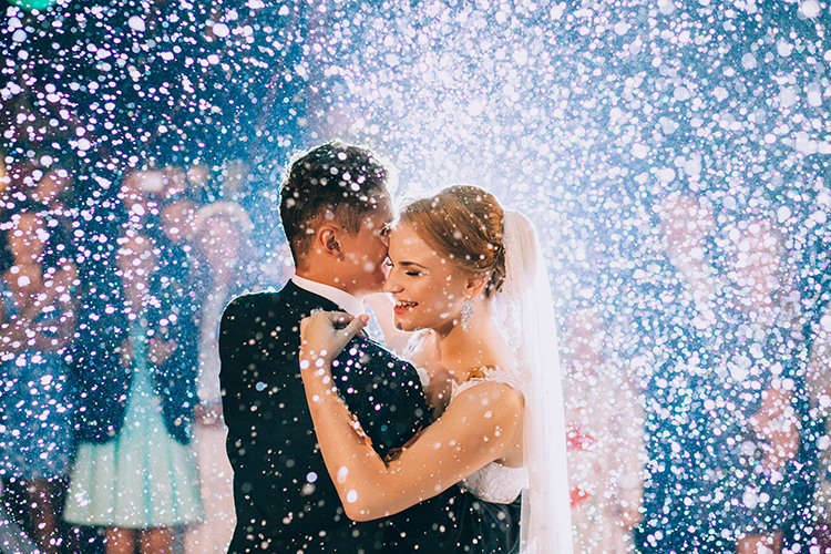 A bride and groom smile and dance